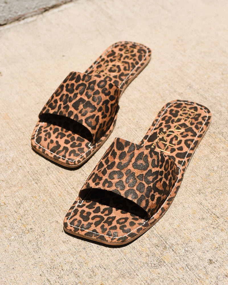 Leopard print sandals on a concrete surface